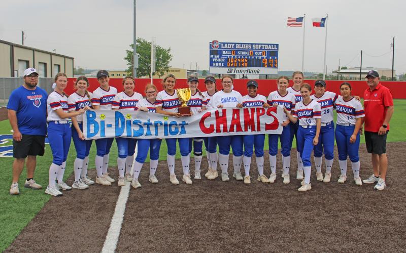 (MIKE WILLIAMS | CONTRIBUTED PHOTO) The Graham Lady Blues players and coaches pose with their bi-district trophy and banner after defeating Lubbock Estacado in two straight games last weekend to claim the championship. The team will move onto the area round of the playoffs this week.