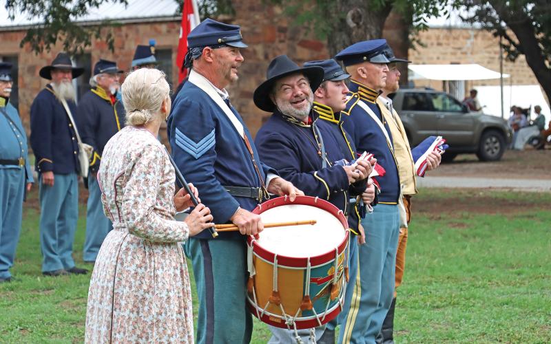 (ARCHIVE PHOTO | THE GRAHAM LEADER) Living history reenactors share a laugh before the flag ceremony at the Fort Belknap Days education event in 2023. The living history event is split up into an education day for students and a public day open to everyone.