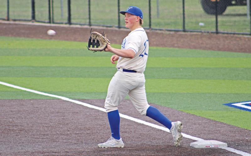 (ALEX HAVARDANSKY | THE GRAHAM LEADER) Colter Johnson warms up at first base for the Steers in their matchup Thursday, April 17 against the Stephenville Yellow Jackets. Johnson proved to be a big impact in this game.