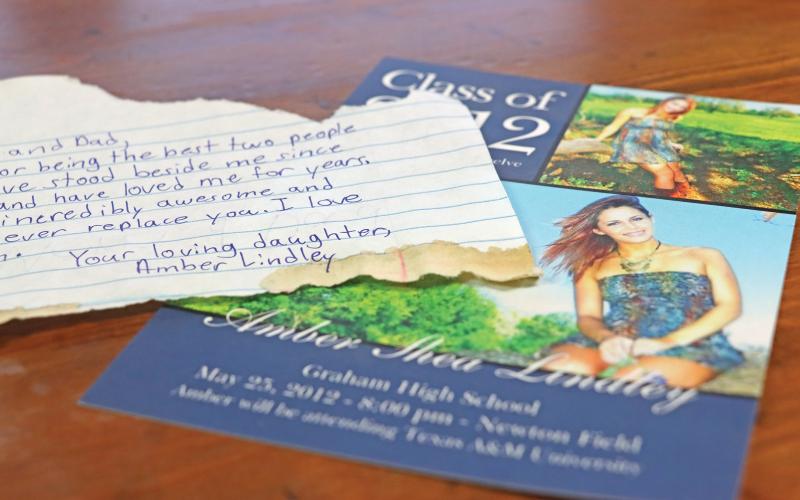 (THOMAS WALLNER | THE GRAHAM LEADER) A note found hidden behind a mirror by Dana Lindley while doing bathroom renovations. The note was from his daughter Amber who passed away in July 2012. Next to the note is a Class of 2012 Graham High School graduation ceremony invitation for Amber.