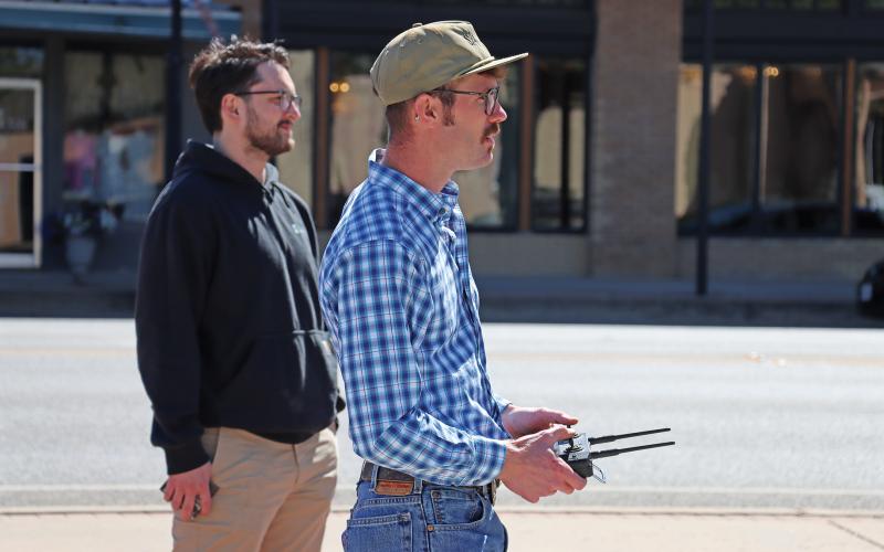(THOMAS WALLNER | THE GRAHAM LEADER) River McTasney controls a Ranch Rover autonomous vehicle Wednesday, April 3  to show off the vehicle to representatives of the city and members of the Graham Economic Improvement Corporation Board of Directors. Shown from left to right are Jay Jones and McTasney who make up part of the team for Smooth Ag.