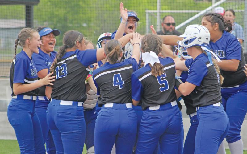 (ALEX HAVARDANSKY | THE GRAHAM LEADER) Zoey Harrell and her teammates celebrate triumphantly at home plate as they advance to the playoffs Friday, April 18. The teams kicks off their postseason schedule this week. 