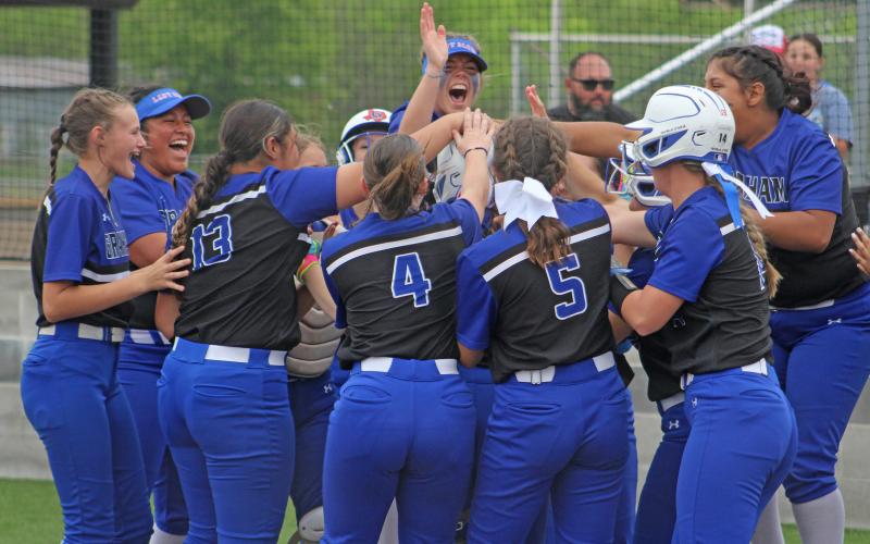 (ALEX HAVARDANSKY | THE GRAHAM LEADER) The Lady Blues celebrate after Zoey Harrell’s walk off home run Friday, April 18. The team’s win over the Mineral Wells Lady Rams would send them to the postseason.