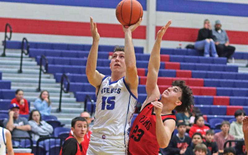 (THOMAS WALLNER | THE GRAHAM LEADER) Ty Thompson jumps to make a shot over a defender from Mineral Wells during the Steers’ victory Friday, Jan. 17. The Graham team was down multiple times in the game but always came back in fighting form.