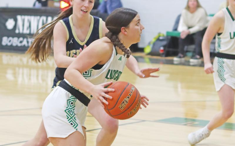 (THOMAS WALLNER | THE GRAHAM LEADER) Emma Hawkins of the Ladycats runs past Perrin defenders to attempt a shot at the net Friday, Jan. 24. The team came away with a big 51-28 win over Perrin and remains perfect in district play at 7-0.