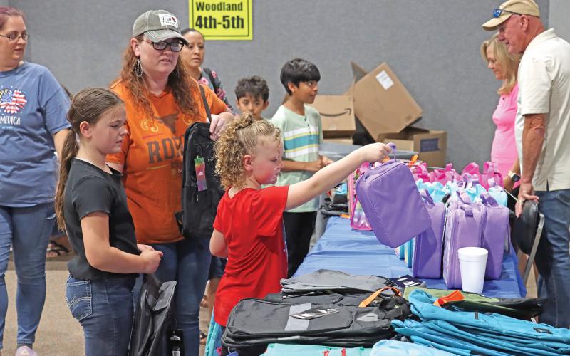(ARCHIVE PHOTO | THE GRAHAM LEADER) A visitor to Graham Up Graham in 2024 picks out a lunch bag to use for the new school year. The annual event distributes school supplies and other necessities for students at no charge.