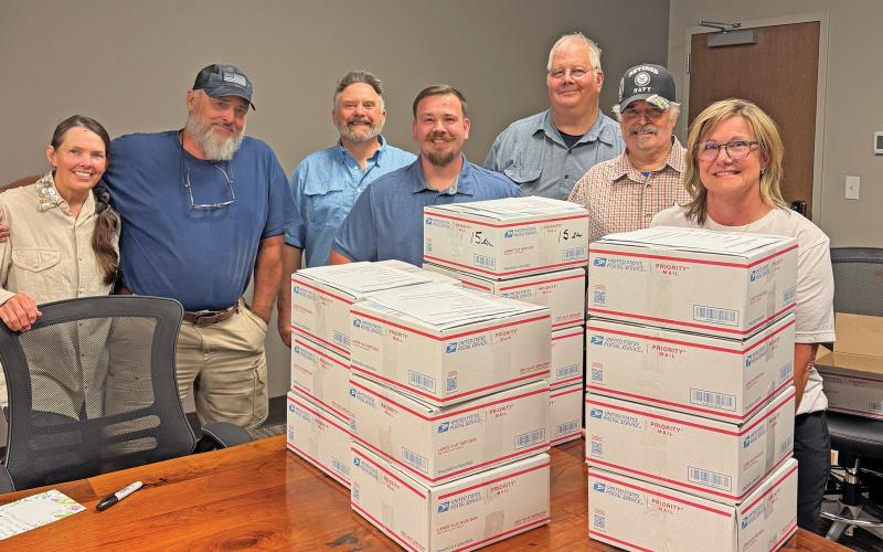 (ANDREA LOWERY | CONTRIBUTED PHOTO) Volunteers and American Legion Post 34 members pose in front of boxes stuffed with goodies, letters and pictures for U.S. Marines. The care packages will be shipped across the globe to four locations.