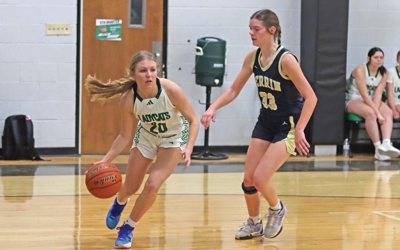 (THOMAS WALLNER | THE GRAHAM LEADER) Catherine Youngblood of the Ladycats dribbles past Perrin players as she looks for an opening to make a shot or pass during the game Friday, Jan. 24. Youngblood was one of the key players for the team during the game.