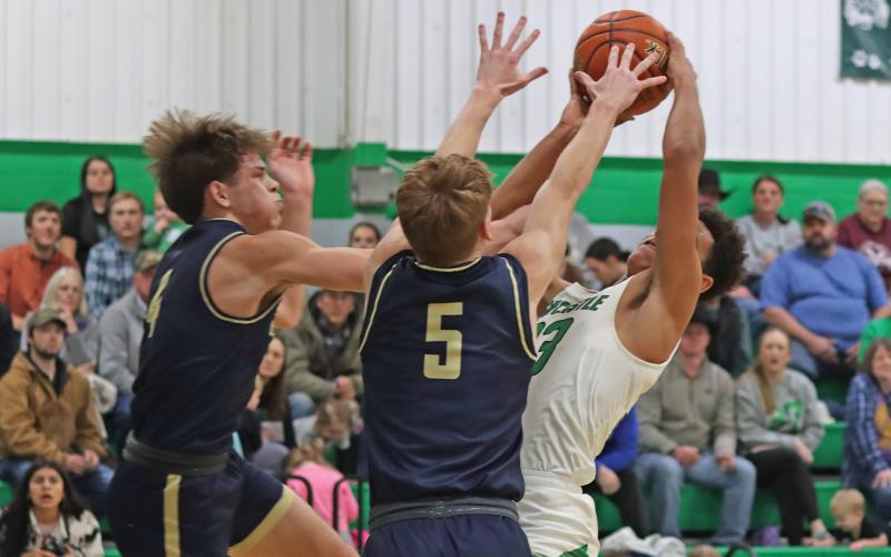 (THOMAS WALLNER | THE GRAHAM LEADER) Jacob Omundi faces a stiff defense from Perrin while attempting a shot at the net Friday, Jan. 24. After the Bobcats fell to Perrin, the team is now moving into the second half of its district schedule. 
