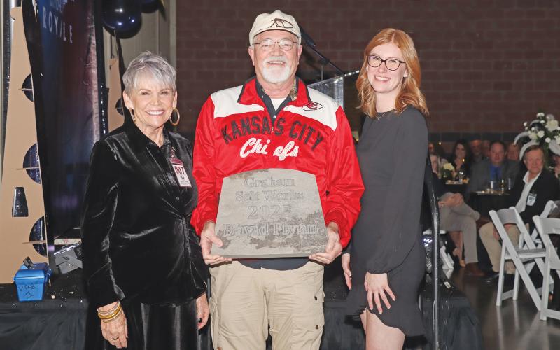 (THOMAS WALLNER | THE GRAHAM LEADER) Citizens of the Year Andy and Dennis Heath pose with their award they won during the 2025 Graham Chamber Banquet at the Young County Arena. The Citizen of the Year award is one of four awards presented during the Grahammy awards ceremony based on community votes.