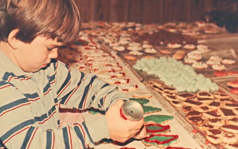(CONTRIBUTED PHOTO | MARY BRADDOCK) Graham Street helps to ice cookies during the Cookie Day event held in 1982 in Graham. The event is still being held to this day and will be from 4-6 p.m. Friday, Dec. 8.