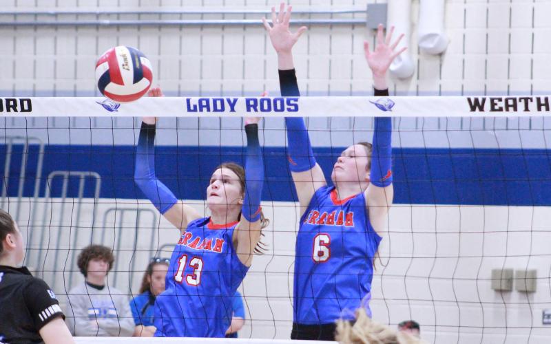 (TC GORDON | THE GRAHAM LEADER) Sophomore Tara Dawson (13) and junior Emilee Gordy (6) jump into the air to try to block a hit from one of Decatur’s players. The Lady Blues lost to the Lady Eagles in three sets which ended their season.