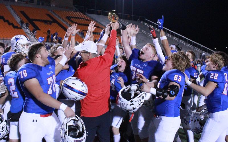 (TC GORDON | THE GRAHAM LEADER) Graham head coach Ken Davidson presents the bi-district championship trophy to his team Friday, Nov. 10 after the Steers defeated the Hillsboro Eagles 56-0. The Steers’ dominant performance will carry them into the area round of the playoffs against West Plains.