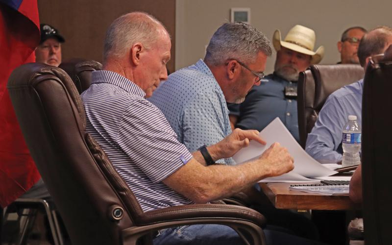 (THOMAS WALLNER | THE GRAHAM LEADER) Graham City Council members Jeff Dickinson and Alex Heartfield look over documents provided by City Manager Eric Garretty during a budget workshop held Thursday, Aug. 7. The city approved a third reading of an ordinance raising the water and sewer rates during the meeting.