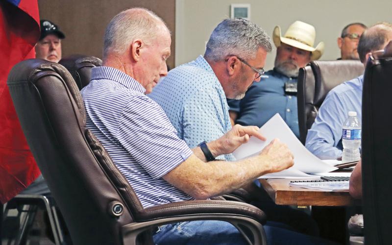 (THOMAS WALLNER | THE GRAHAM LEADER) Graham City Council member Jeff Dickinson and Mayor Alex Heartfield look over documents provided by City Manager Eric Garretty during a budget workshop Aug. 7, 2025. The city approved raising the water and sewer rates during the meeting and will consider another increase this year.