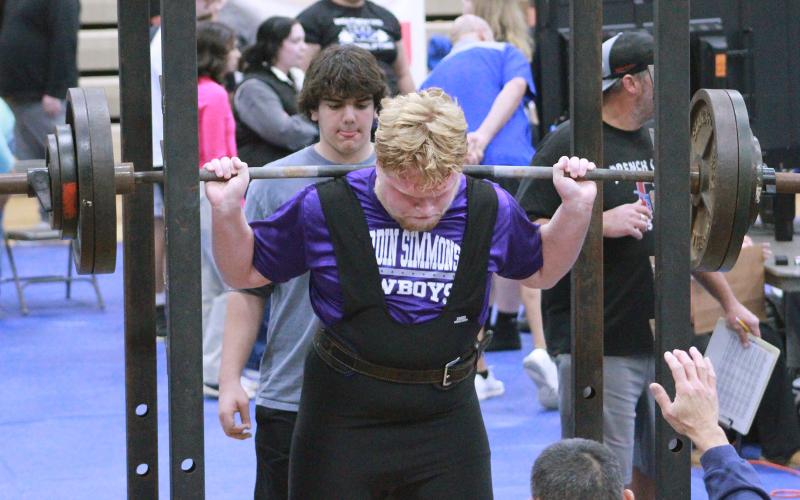 (TC GORDON | THE GRAHAM LEADER) Kaleb Crawford, of Graham’s powerlifting team, sets his feet in the right position for one of his squat lifts during a meet earlier this season. The Steers recently competed at a powerlifting Last Chance Qualifier event, and five of them have qualified for the regional meet Saturday, March 2.