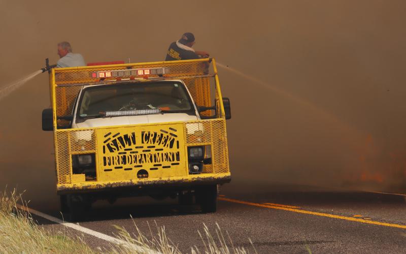 (THOMAS WALLNER | THE GRAHAM LEADER) Members of Salt Creek Volunteer Fire Department fight a grass fire on FM 209 in September. The department received a $20,000 grant from the Oncor Cares Foundation.