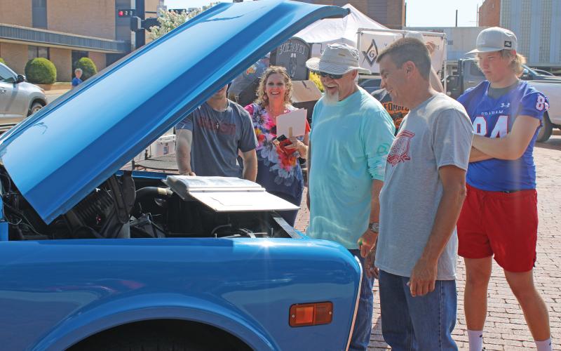 (ARCHIVE PHOTO | THE GRAHAM LEADER) A group gathers around a vehicle shown off at the 12th annual Cars and Stars car show on the Graham downtown square. The event was canceled last year, but will be returning to the square from 10 a.m. to 2 p.m. Saturday, Oct. 12.