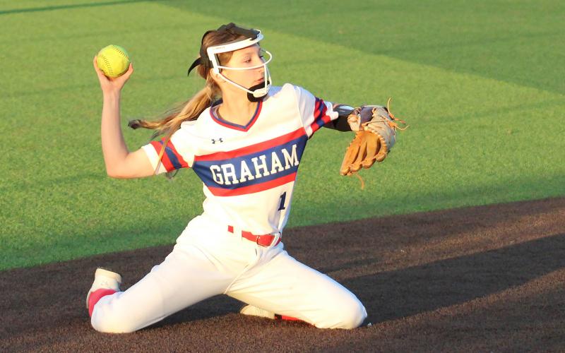(TC GORDON | THE GRAHAM LEADER) Graham’s Tiffany Cotter makes a throw to first base from her knees during one of the team’s games at the Iowa Park tournament over last weekend. The Lady Blues went 1-4 in five games against tough competition.