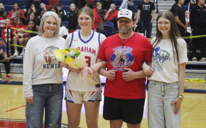 (ALEX HAVARDANSKY | THE GRAHAM LEADER) Briley Randall poses for pictures with her family Tuesday, Feb. 10 on senior night. The Lady Blues were able to send Randall off on a high note with a 45-35 victory over Mineral Wells. 
