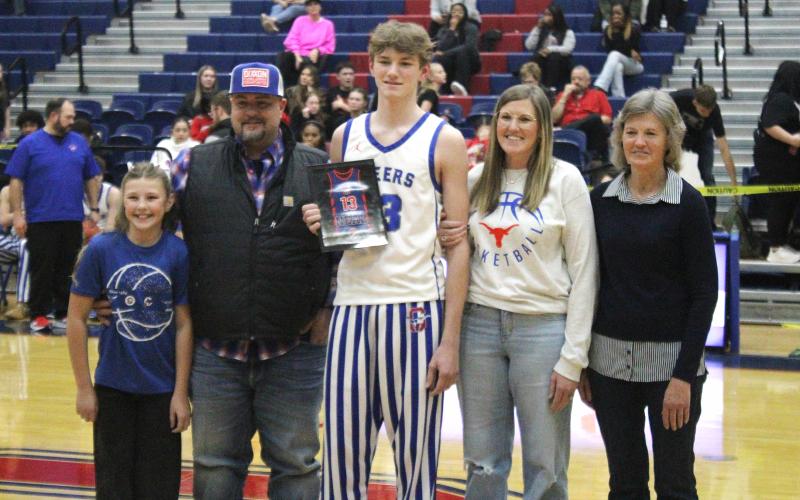 (ALEX HAVARDANSKY | THE GRAHAM LEADER) Jaden Neal stands with his family Tuesday, Feb. 10 on senior night. The Steers sent Neal off on a high note with a 58-37 win over the Mineral Wells Rams.