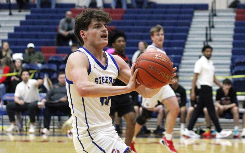 (ALEX HAVARDANSKY | THE GRAHAM LEADER) Brodie Martin passes the ball to a teammate Tuesday, Feb. 10 against the Mineral Wells Rams. The Steers were locked in offensively from the opening quarter and came away with a 58-37 victory to clinch a playoff spot. 