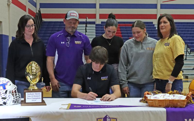 (THOMAS WALLNER | THE GRAHAM LEADER) Bruin Wright signs to play football for Hardin-Simmons University during a Graham High School athletes signing ceremony Wednesday, Feb. 5.