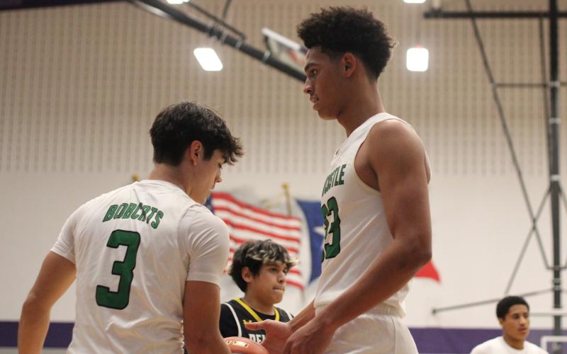 (ALEX HAVARDANSKY | THE GRAHAM LEADER) Jacob Omundi, 33, and Keyton Newland, 3, stand tall Monday, Feb. 23 against the Bellevue Eagles. The Bobcats fought hard in their bi-district matchup but lost 49-32. 