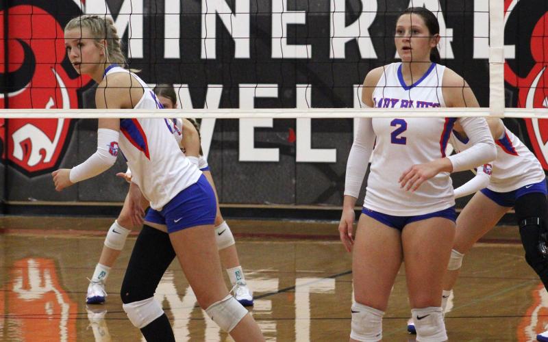 (ALEX HAVARDANKSY | THE GRAHAM LEADER) Kya Cooper, left, and Madison Cauble, right, prepare for a defensive possession Friday, Oct. 24, against Mineral Wells. The Lady Blues fought but lost to the Lady Rams in five sets. 