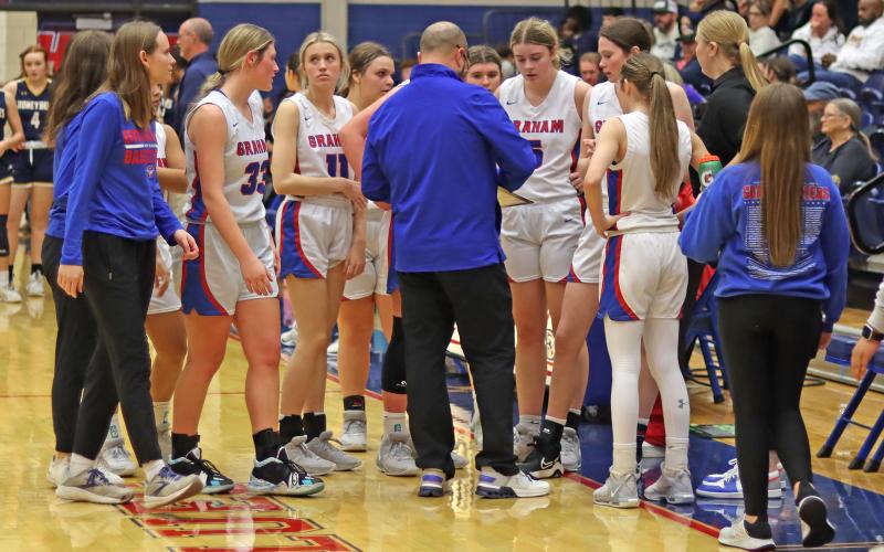 (THOMAS WALLNER | THE GRAHAM LEADER) Head coach Kyle Wood (center) speaks to his team during a timeout of Graham’s matchup with Stephenville last Friday, Jan. 26. The Lady Blues fought hard but lost 49-25 to the visiting Honeybees.