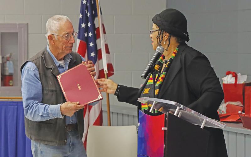(THOMAS WALLNER | THE GRAHAM LEADER) Rev. Vanessa Sims hands a certificate Saturday, Feb. 15 to John Bullock for his contributions to the Oak Grove Colored - William P. Johnston Cemetery research project.