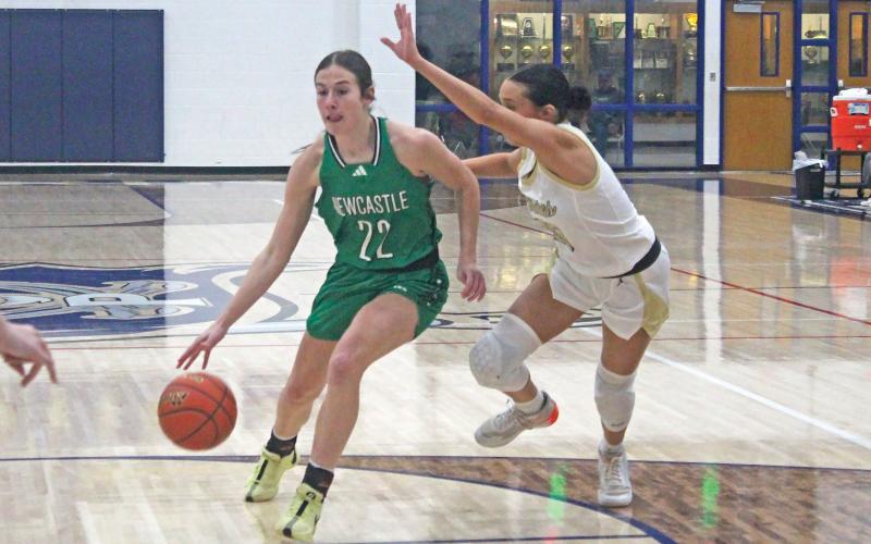 (BRIAN SMITH | JACKSBORO HERALD-GAZETTE) Newcastle’s Mattie Dollar (22) looks to drive inside with a pair of Perrin defenders close by. Dollar had 28 points and eight rebounds as the Ladycats remained perfect in district play with a 55-33 win. 