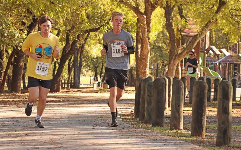 (THOMAS WALLNER | THE GRAHAM LEADER) Two runners in the 2024 Spivey Hill Challenge round the corner near the Firemen’s Park playground. Trails at the park will be expanded soon.
