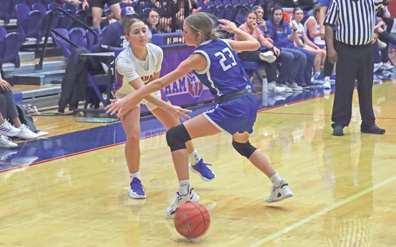 (TC GORDON | THE GRAHAM LEADER) Graham’s Ava Street passes the ball to a teammate under the arms of a Stamford defender Tuesday, Nov. 19 during the team’s 45-35 win.