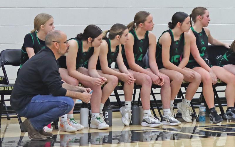 (THOMAS WALLNER | THE GRAHAM LEADER) Head coach Ryan Dollar and the Ladycats watch the team play defense at the opposite side of the court Friday, Feb. 21. Despite the team falling to Neches, it closed out a successful season.