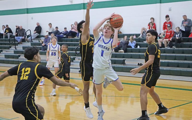 (ARCHIVE PHOTO | THE GRAHAM LEADER) Tyler Allen of the Steers races past defenders to set up a shot during a tournament earlier in the season. The Steers matched up against the Henrietta Bearcats, but came up short in a 50-43 loss Tuesday, Dec. 10.  