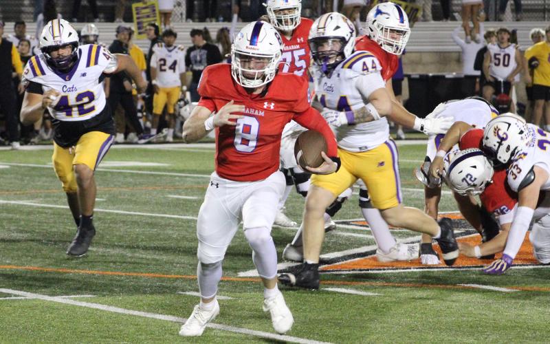 (ALEX HAVARDANSKY | THE GRAHAM LEADER) Jace Gill runs out of the pocket to the sideline Friday, Nov. 14 against the Godley Wildcats. Gill was very effective extending drives with his legs leading to multiple scores in the game.