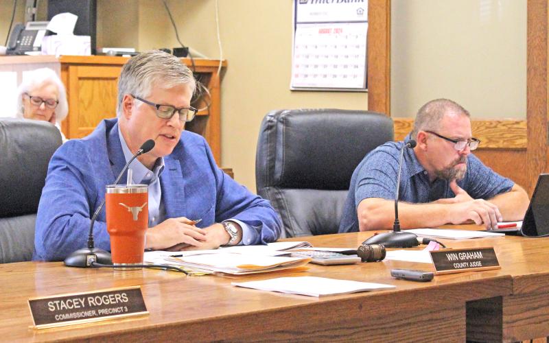 (TC GORDON | THE GRAHAM LEADER) Young County Judge Win Graham (left) reads a statement about the budget process before the start of public hearings for the 2024-2025 fiscal year tax rate and budget. Following the hearings Monday, Aug. 26, the county commissioners voted to adopt the tax rate and budget.