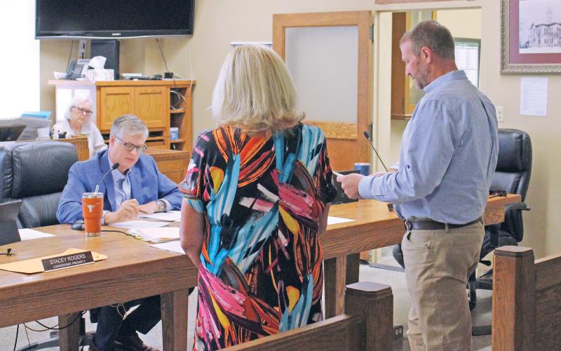 (TC GORDON | THE GRAHAM LEADER) Justin Gilmore of Level 5 Architecture (right) presents the only bid the county received for renovation work of the former tax assessor-collector’s office at commissioners court Monday, Aug. 26. The project will be on hold as the only bid came in higher than anticipated and commissioners want to evaluate if it can be lowered.