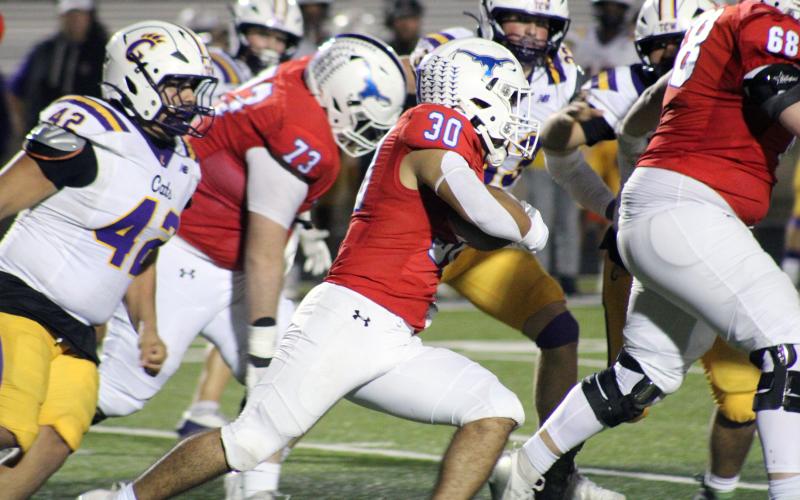(ALEX HAVARDANSKY | THE GRAHAM LEADER) Mike Garcia runs to the outside of the backfield Friday, Nov. 14 against the Godley Wildcats. Garcia broke off multiple big runs in the contest to put the Steers in quality field position.