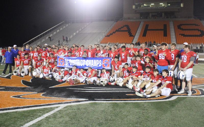 (ALEX HAVARDANSKY | THE GRAHAM LEADER)  The Steers pose with their Bi-District Champs banner and trophy after winning their opening round playoff matchup Friday, Nov. 14. Head coach Clay McChristian said he was proud of the team’s preparation heading into this matchup. 