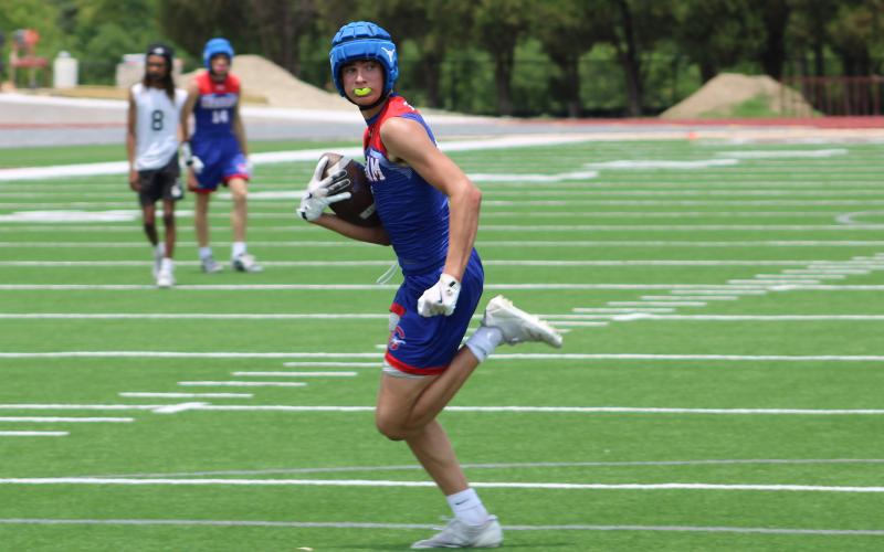 (ALEX HAVARDANSKY | THE GRAHAM LEADER) Walker Bennett catches a ball over the middle of the field and takes it all the way for a touchdown Saturday, May 31. Bennett came into his own on this day making multiple impact plays in the passing game to help Graham secure their spot in the state tournament.