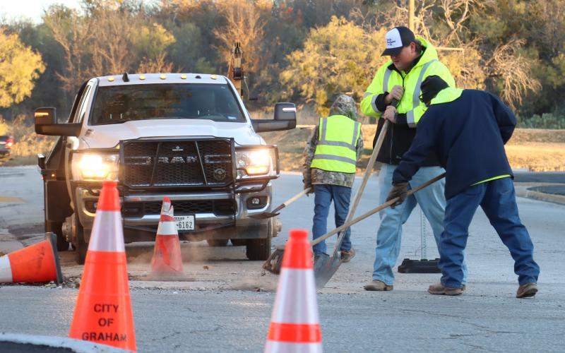(THOMAS WALLNER | THE GRAHAM LEADER) Workers sweep an area as part of a redesign of Third and Cherry Street to make the intersection a four-way stop. The redesign was approved by the Graham City Council in August.