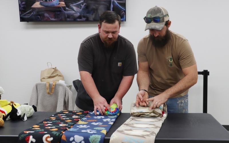 (THOMAS WALLNER | THE GRAHAM LEADER) Adam LaVine and Curtis Strider wrap stuffed animals and goody bags in blankets which were bundled and will be delivered to first responders in Young County. First responders will provide those bundles to children in crisis situations.