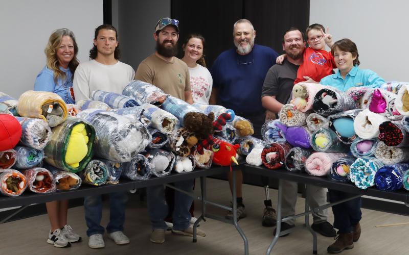 (THOMAS WALLNER | THE GRAHAM LEADER) Volunteers pose for a group photo after wrapping 153 bundles of blankets, stuffed animals and goody bags which will be delivered to Young County first responders. The bundles will be used when county first responders respond to a situation with a child in crisis.