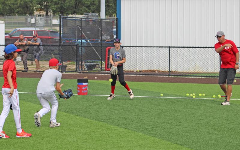 (ALEX HAVARDANSKY | THE GRAHAM LEADER) Adam Arrington runs drills with Steers campers for Steers baseball camp Tuesday, June 3. Arrington serves as the Lady Blues softball head coach.