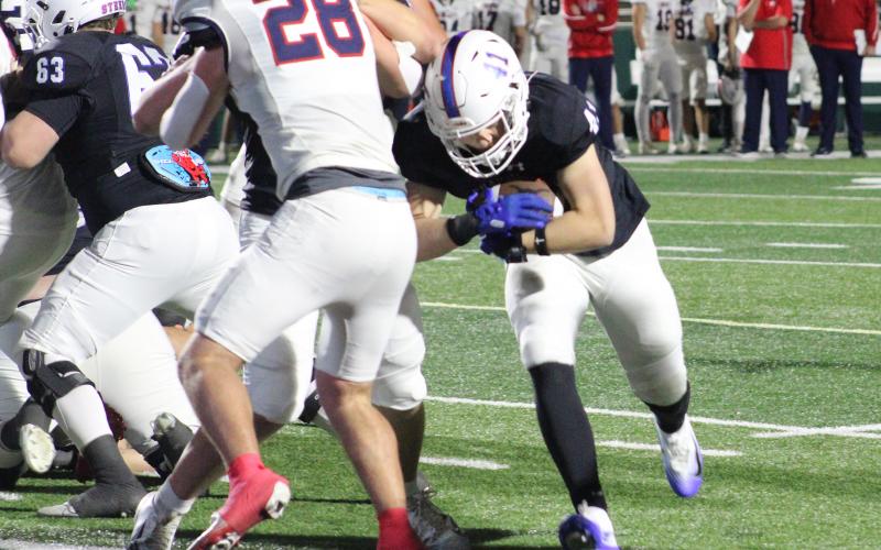 (ALEX HAVARDANKSY | THE GRAHAM LEADER) Dylan Cox leans forward and runs through a defender into the endzone Friday, Nov. 21. Cox scored a go ahead touchdown to open the fourth quarter and make it 28-21 Graham.