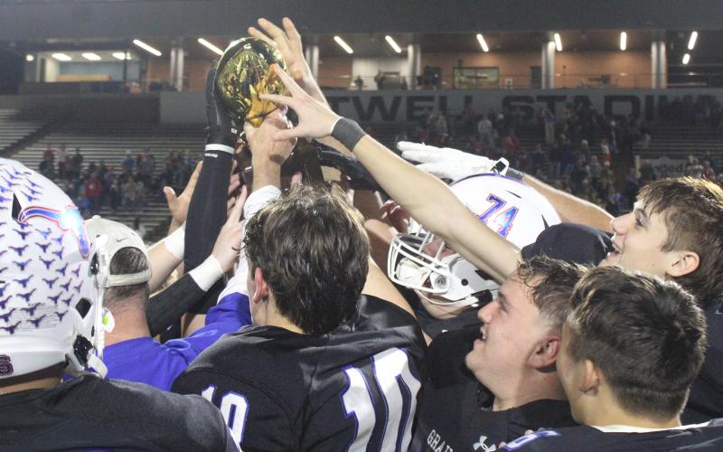 (ALEX HAVARDANSKY | THE GRAHAM LEADER) The Steers celebrate with their area championship trophy Friday, Nov. 21. Several members of the Steers were selected for all-district awards to honor their excellence as athletes as well as students. 