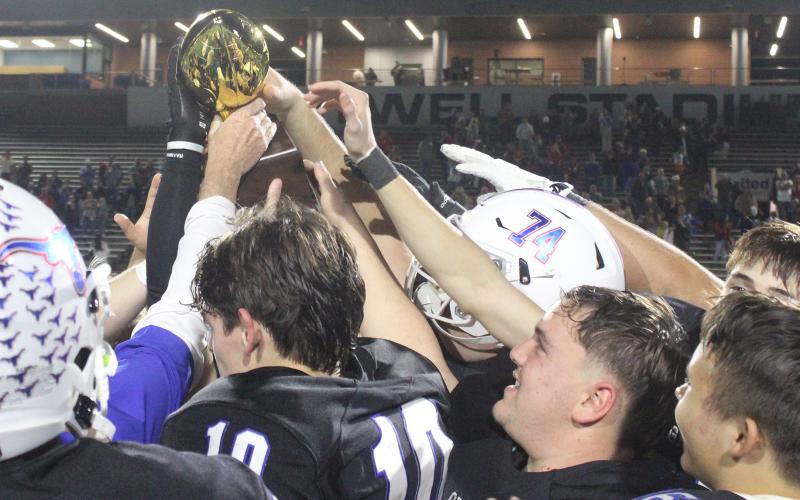 (ALEX HAVARDANKSY | THE GRAHAM LEADER) The Steers celebrate with their area championship trophy Friday, Nov. 21 after defeating the Lubbock-Cooper Liberty Patriots 35-28. Head coach Clay McChristian said he was proud of the team’s fight against a tough opponent. 