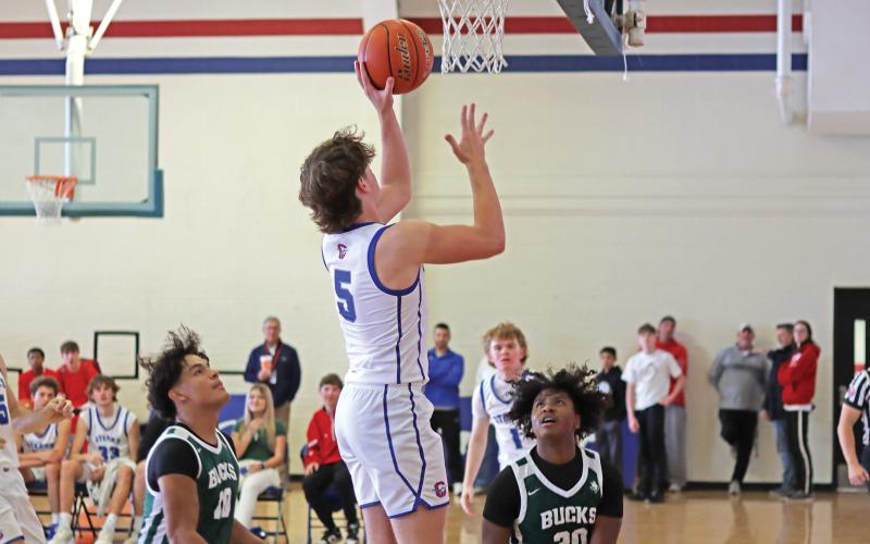 (THOMAS WALLNER | THE GRAHAM LEADER) Steers sophomore Cooper Corley jumps over Breckenridge Buckaroos defenders for a layup during day one of the Red, White & Blue Tournament held Thursday, Dec. 12 in Graham. The Steers placed third in the varsity boys division.